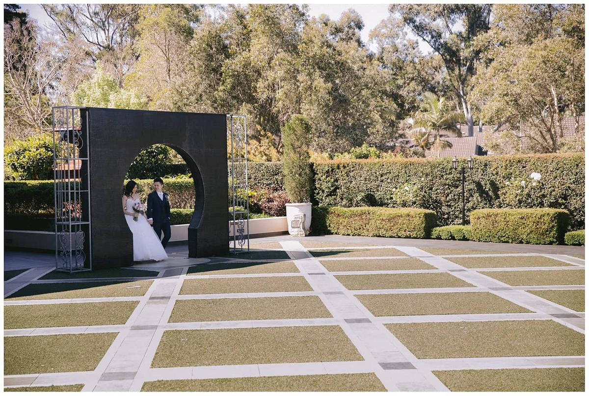 The bride and groom walking to Eternal Garden at Curzon Hall.